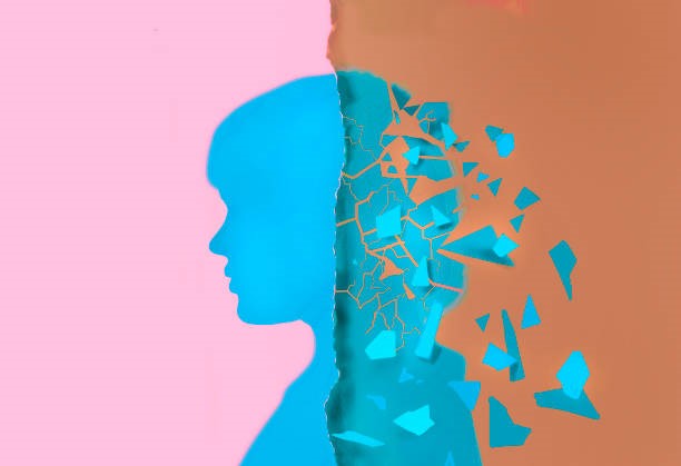 A person’s silhouette split with one side fragmenting into scattered pieces.